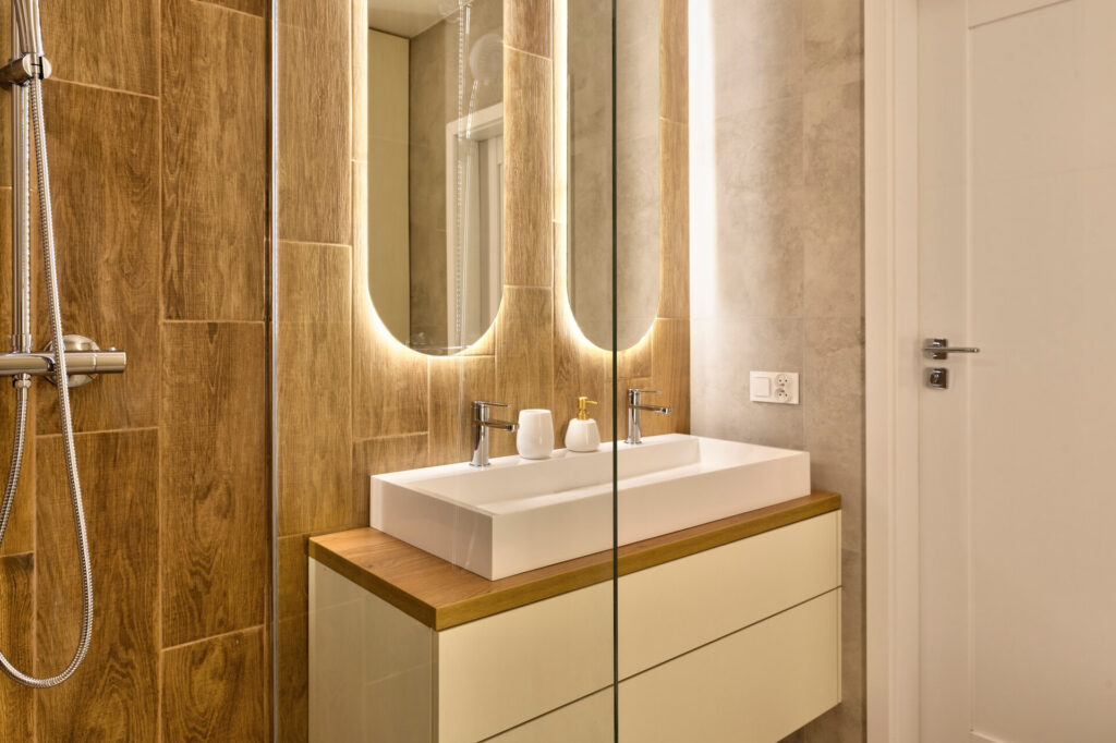 Ein Bad mit zwei Spiegeln die mit LED ausgestattet sind