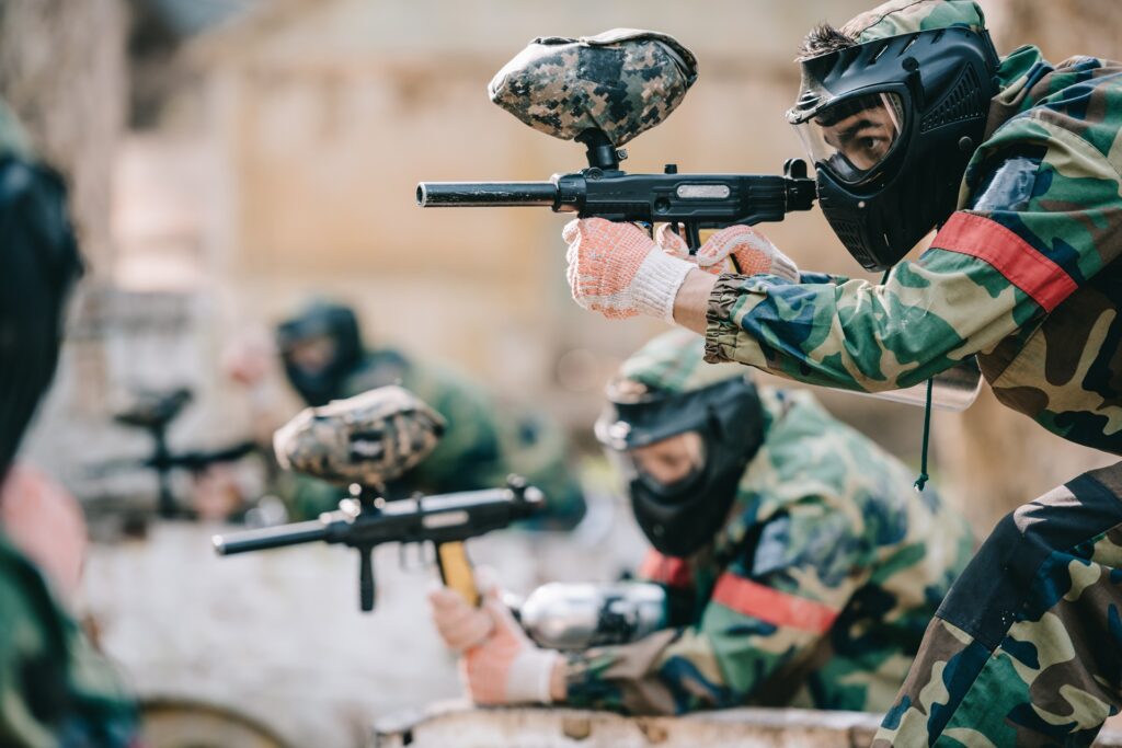 Team beim Paintball mit Druckluftwaffen im Gelände