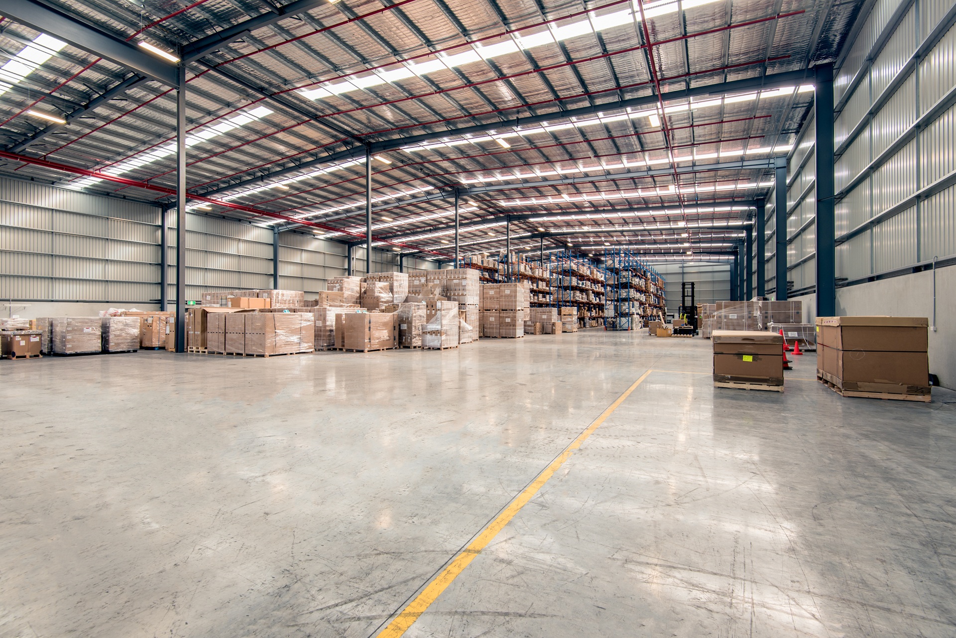 Weitläufige Industriehalle mit Kartons und Regalen | Lagerhalle